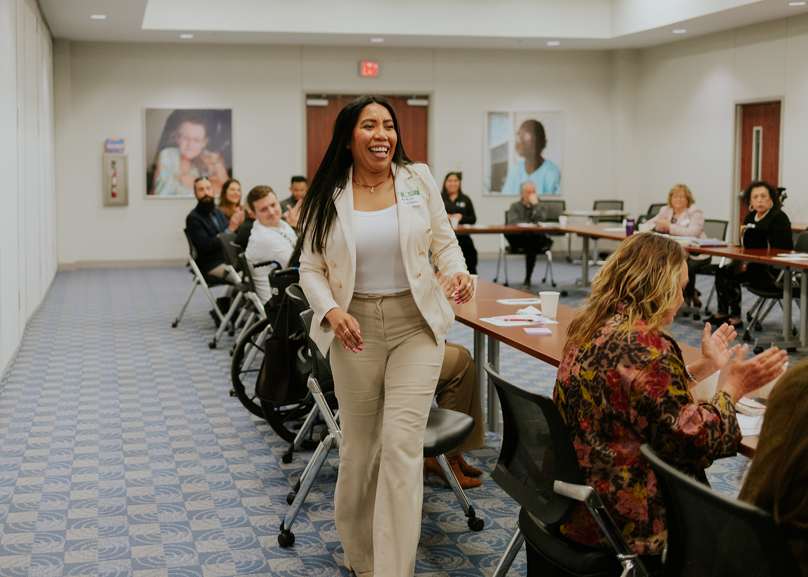 A nonprofit leader greeted with applause at a Roots to Leadership gathering